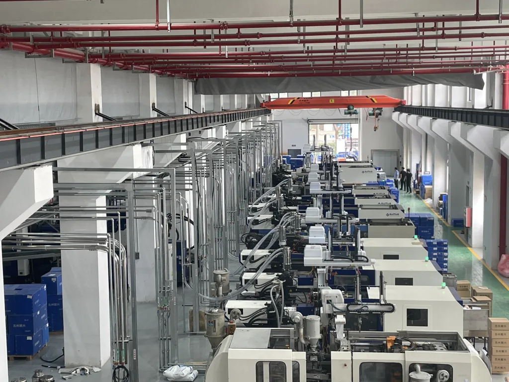 Injection molding lines with centralized overhead utility piping