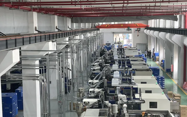 Injection molding lines with centralized overhead utility piping
