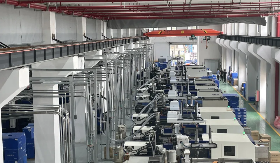 Injection molding lines with centralized overhead utility piping
