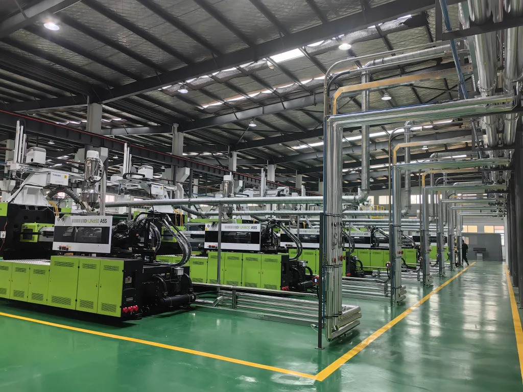 Clean injection molding workshop with organized utility piping
