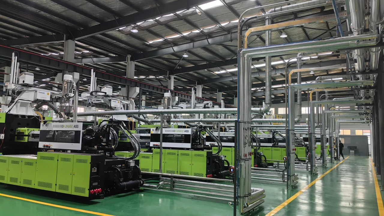 Clean injection molding workshop with organized utility piping