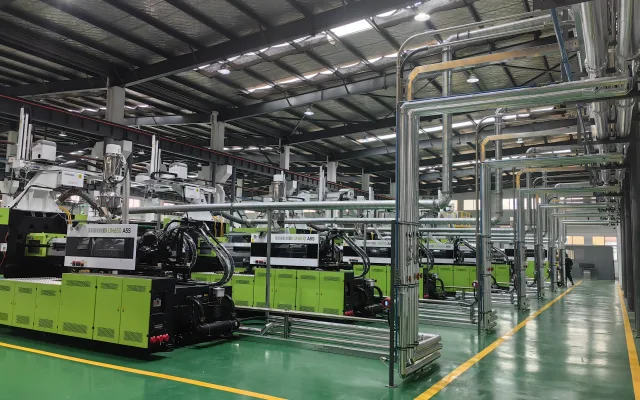 Clean injection molding workshop with organized utility piping