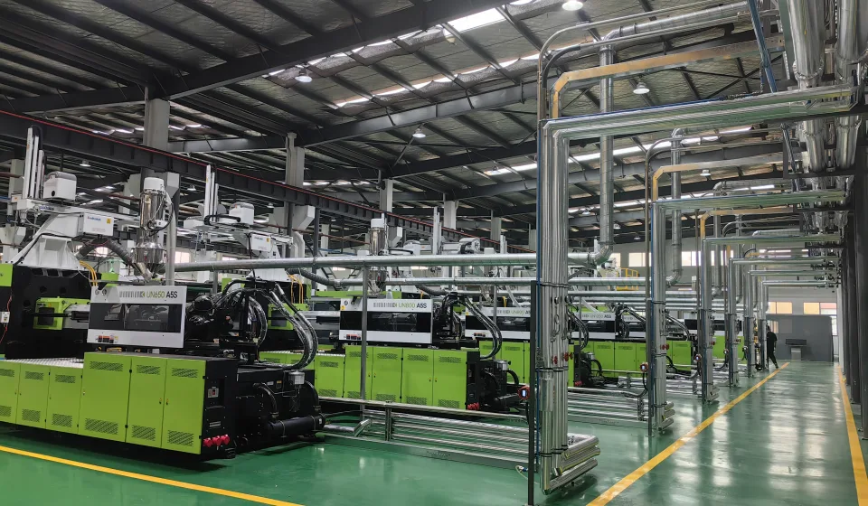 Clean injection molding workshop with organized utility piping