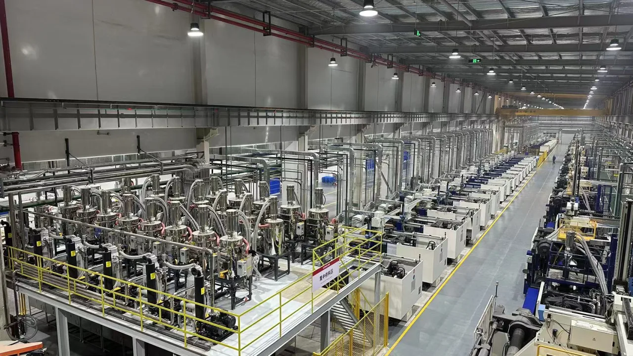 Large injection molding hall with centralized material conveying