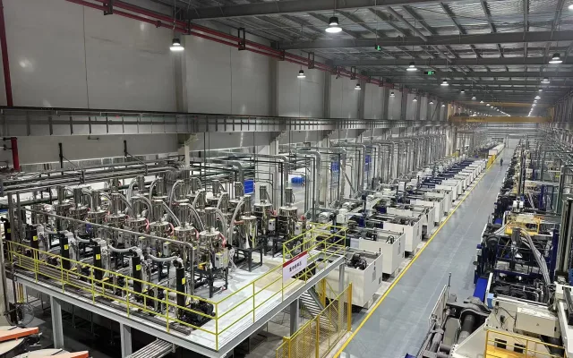 Large injection molding hall with centralized material conveying