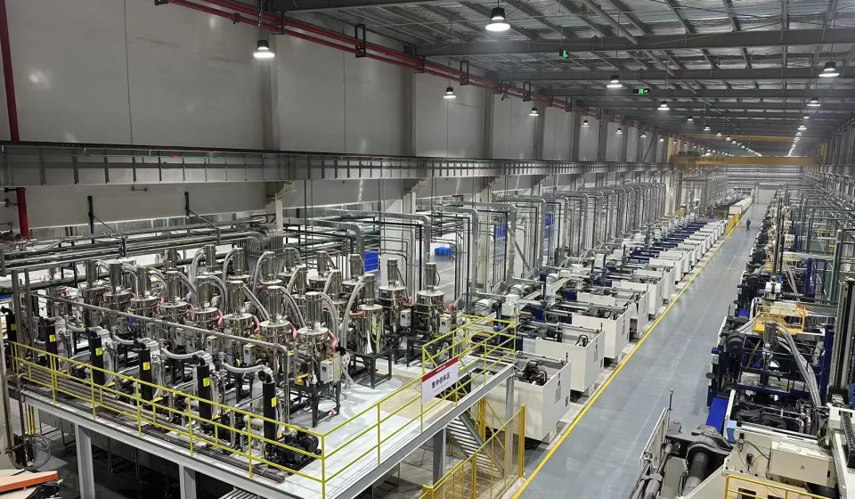 Large injection molding hall with centralized material conveying